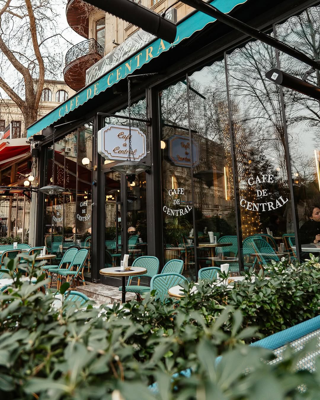 Café de Central exterior at golden hour, with the iconic teal awning and gold lettering